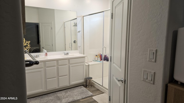 bathroom with vanity, an enclosed shower, and hardwood / wood-style floors