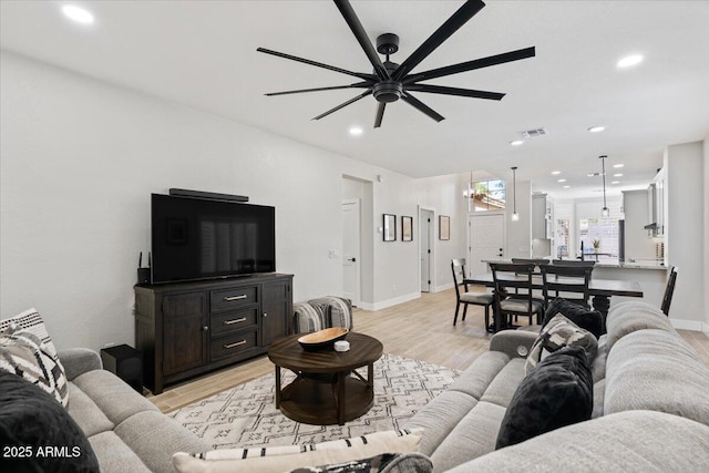 living room with ceiling fan and light wood-type flooring