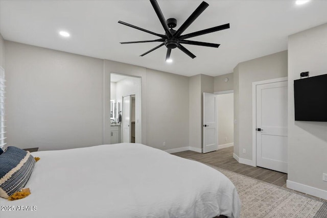 bedroom with ensuite bathroom, ceiling fan, and light wood-type flooring