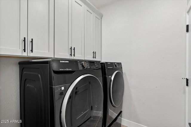 laundry room with cabinets and washing machine and clothes dryer