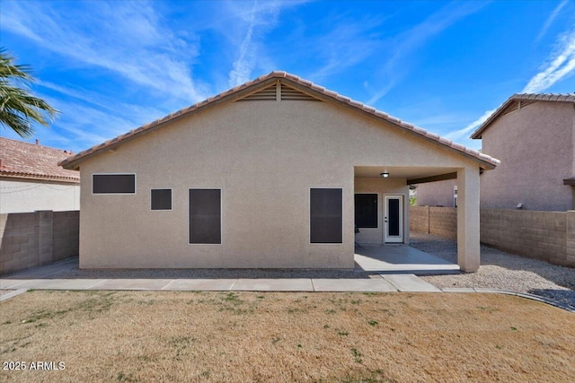 back of house featuring a patio and a yard