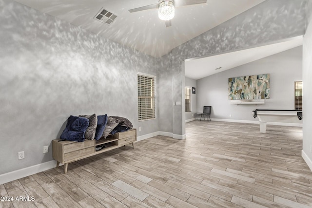 living area with vaulted ceiling, light hardwood / wood-style flooring, and ceiling fan