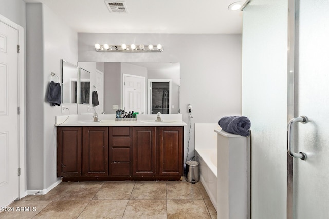 bathroom with a bathing tub, tile patterned flooring, and vanity