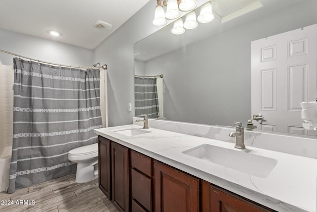 bathroom featuring curtained shower, vanity, wood-type flooring, and toilet