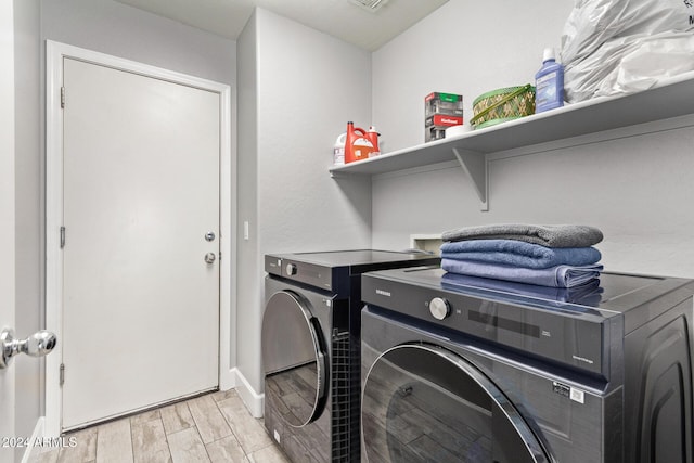 washroom with light wood-type flooring and washer and clothes dryer