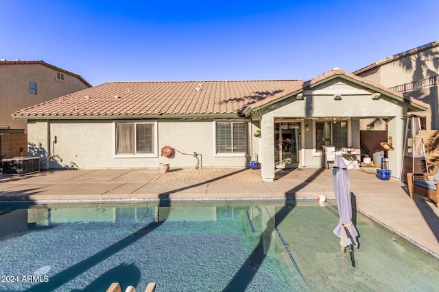 view of swimming pool with central air condition unit and a patio area