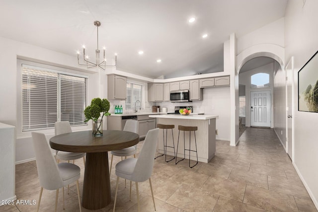 dining room featuring lofted ceiling, an inviting chandelier, and sink