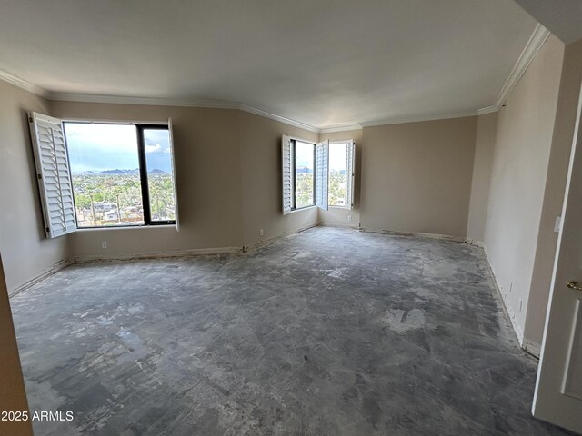 spare room featuring crown molding and baseboards