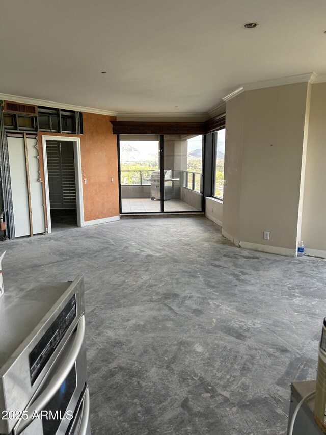 unfurnished living room featuring crown molding, concrete flooring, and baseboards
