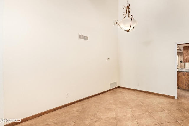4922 W Fallen Leaf Ln, Glendale, AZ 85310 - empty room featuring light tile patterned floors, a high ceiling, and baseboards