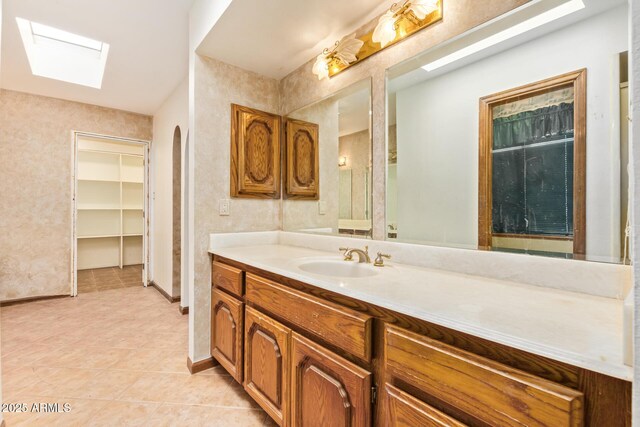 4922 W Fallen Leaf Ln, Glendale, AZ 85310 - bathroom featuring a skylight, vanity, tile patterned floors, and baseboards