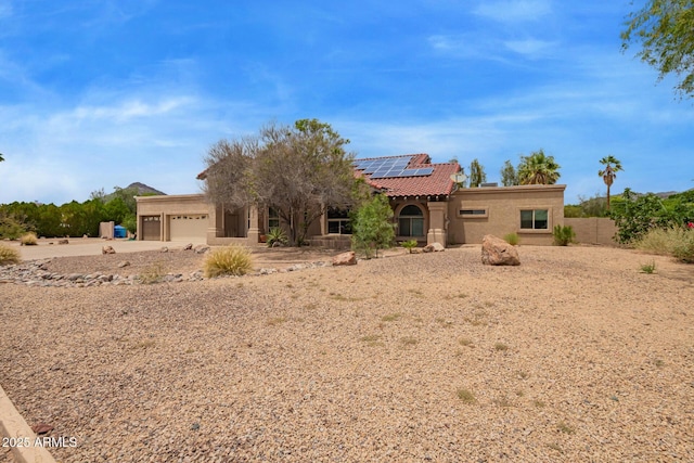 4922 W Fallen Leaf Ln, Glendale, AZ 85310 - view of front of house featuring solar panels, a garage, a tile roof, stucco siding, and driveway