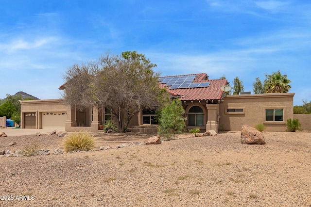 4922 W Fallen Leaf Ln, Glendale, AZ 85310 - view of front of house featuring an attached garage, solar panels, stucco siding, concrete driveway, and a tiled roof