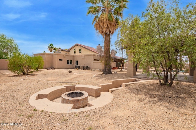 4922 W Fallen Leaf Ln, Glendale, AZ 85310 - rear view of property with an outdoor fire pit, stucco siding, a chimney, and a patio