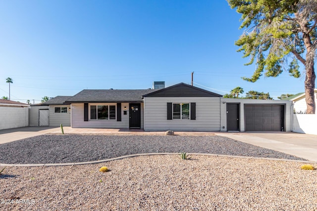 ranch-style house featuring driveway, an attached garage, and fence