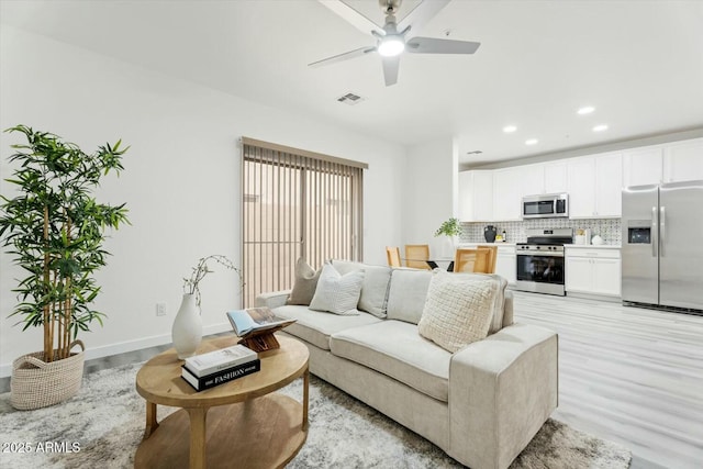 living room featuring light wood-style flooring, recessed lighting, baseboards, and ceiling fan