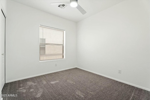 carpeted spare room with a ceiling fan, visible vents, and baseboards