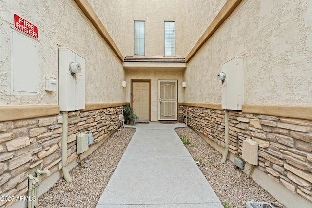 view of exterior entry with stone siding and stucco siding