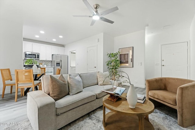 living room featuring recessed lighting, baseboards, light wood-type flooring, and ceiling fan