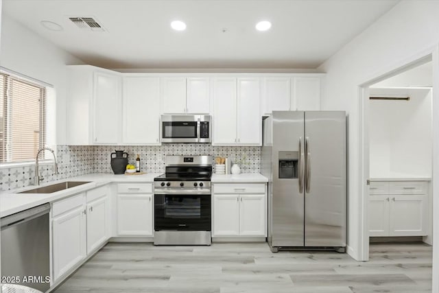 kitchen with visible vents, backsplash, appliances with stainless steel finishes, and a sink