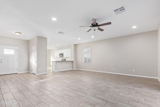 unfurnished living room featuring ceiling fan