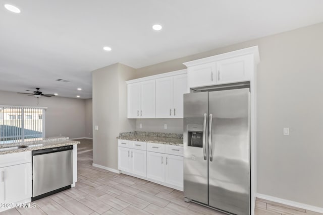 kitchen featuring white cabinets, light stone countertops, and appliances with stainless steel finishes