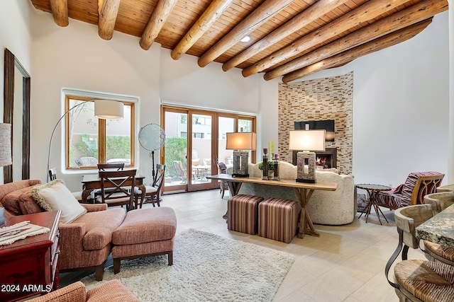 tiled living room with beam ceiling, a large fireplace, wood ceiling, and a high ceiling