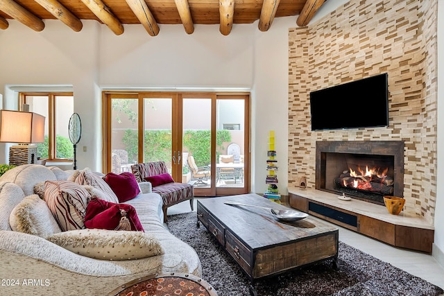 tiled living room with beam ceiling, french doors, wooden ceiling, and a tiled fireplace