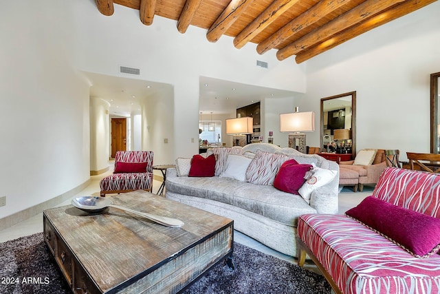 living room featuring beam ceiling, wooden ceiling, and a high ceiling