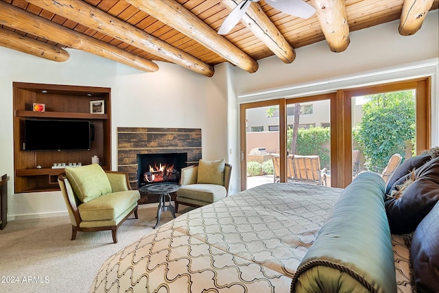 bedroom featuring beam ceiling, access to outside, a stone fireplace, and wood ceiling