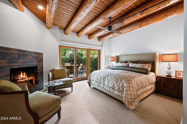 carpeted bedroom featuring a stone fireplace, ceiling fan, beamed ceiling, and wooden ceiling