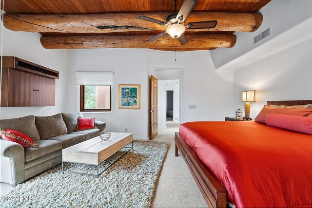 carpeted bedroom featuring beam ceiling and ceiling fan