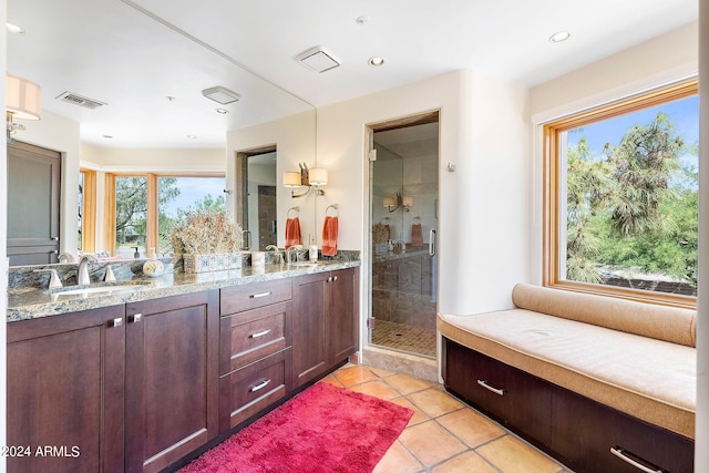 bathroom with tile patterned flooring, vanity, and an enclosed shower