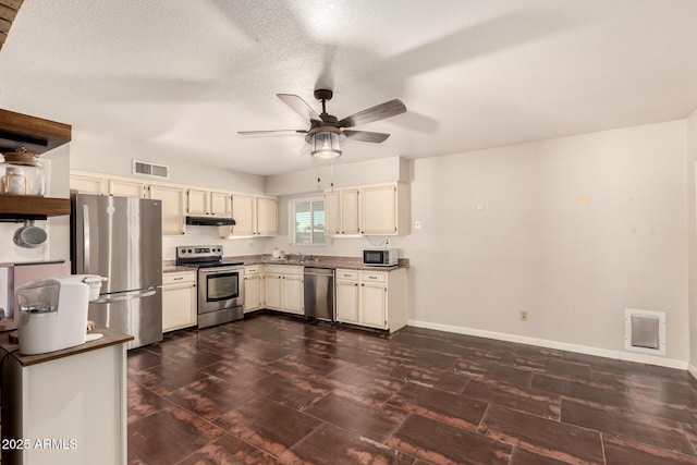 1676 W Sequoia Dr, Phoenix, AZ 85027 - kitchen with appliances with stainless steel finishes, a ceiling fan, dark wood-style flooring, cream cabinets, and a textured ceiling