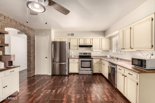 1676 W Sequoia Dr, Phoenix, AZ 85027 - kitchen featuring appliances with stainless steel finishes, cream cabinetry, a ceiling fan, dark wood-style flooring, and arched walkways