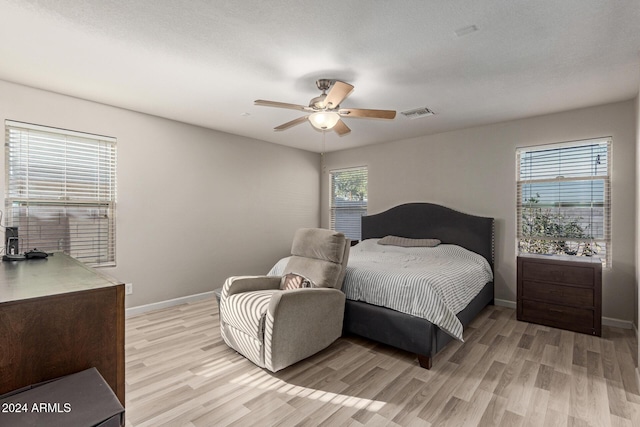 bedroom featuring a textured ceiling, light hardwood / wood-style floors, and ceiling fan