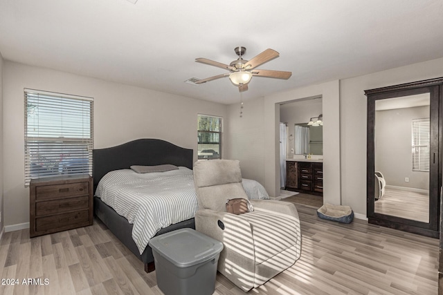 bedroom featuring ceiling fan, light hardwood / wood-style flooring, and ensuite bathroom