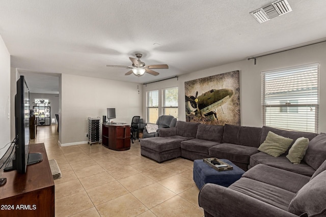 tiled living room featuring a textured ceiling and ceiling fan