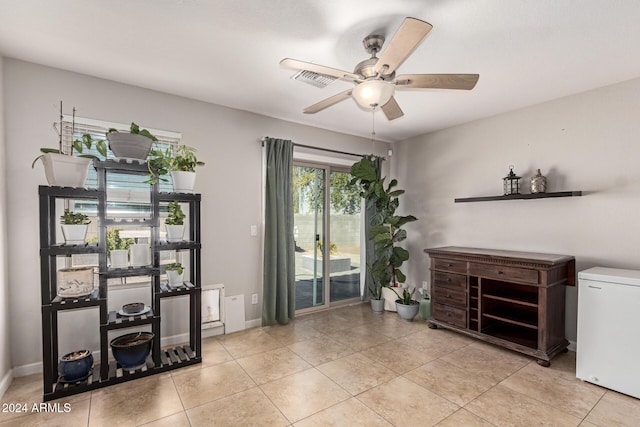 interior space featuring light tile patterned floors and ceiling fan