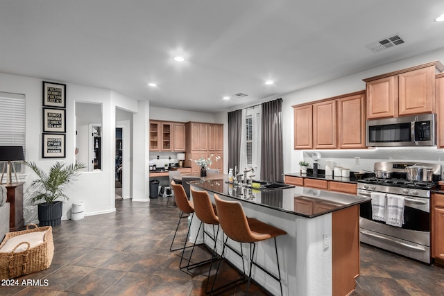 kitchen with a kitchen bar, a kitchen island, sink, and stainless steel appliances