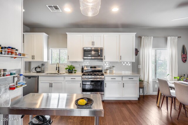 kitchen with sink, dark hardwood / wood-style flooring, appliances with stainless steel finishes, tasteful backsplash, and white cabinetry