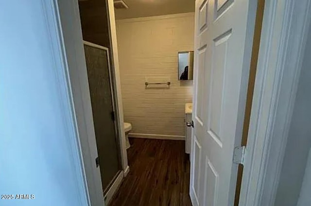 bathroom featuring hardwood / wood-style flooring, vanity, a shower with shower door, and toilet