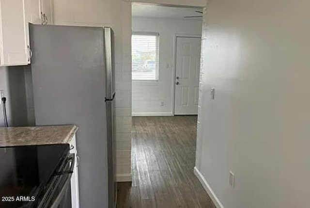 kitchen featuring stainless steel fridge, dark hardwood / wood-style floors, and white cabinets