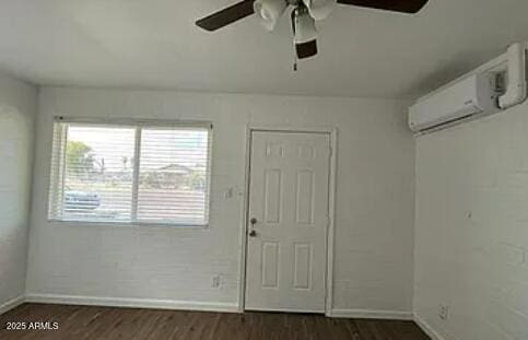 foyer featuring dark hardwood / wood-style floors, a wall mounted air conditioner, and ceiling fan