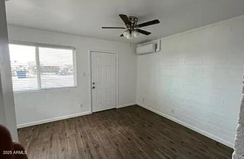 empty room with ceiling fan, dark hardwood / wood-style floors, and a wall mounted AC