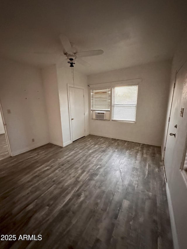 unfurnished bedroom featuring cooling unit, ceiling fan, and dark hardwood / wood-style flooring