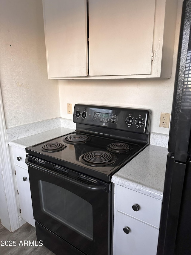 kitchen with hardwood / wood-style floors and black appliances