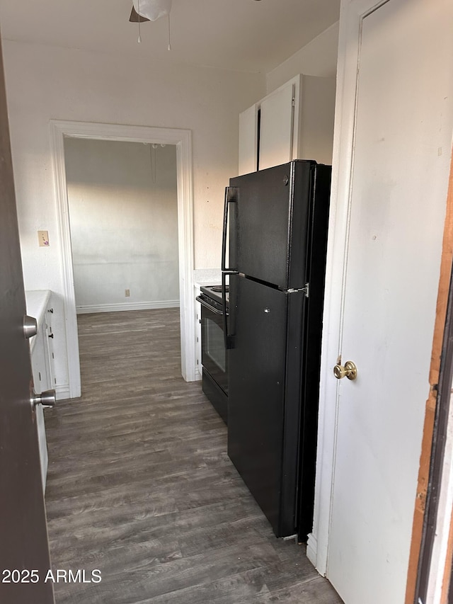 kitchen with dark hardwood / wood-style flooring, black appliances, and white cabinets