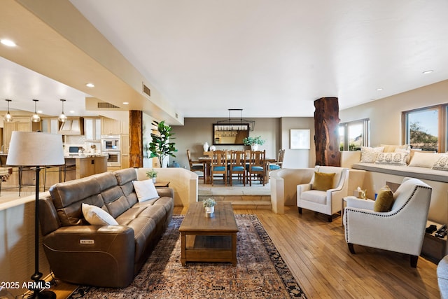 living area featuring light wood-style floors, recessed lighting, and visible vents