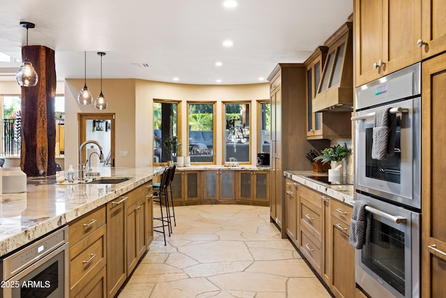 kitchen with brown cabinetry, stainless steel double oven, a sink, and recessed lighting